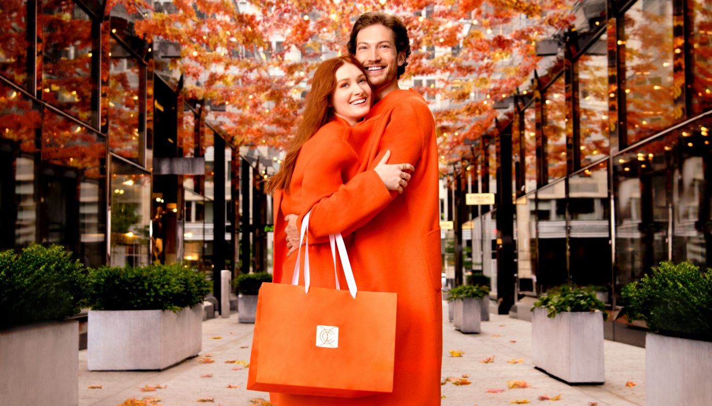 A man and woman share an orange coat in Palmer Alley at CityCenterDC