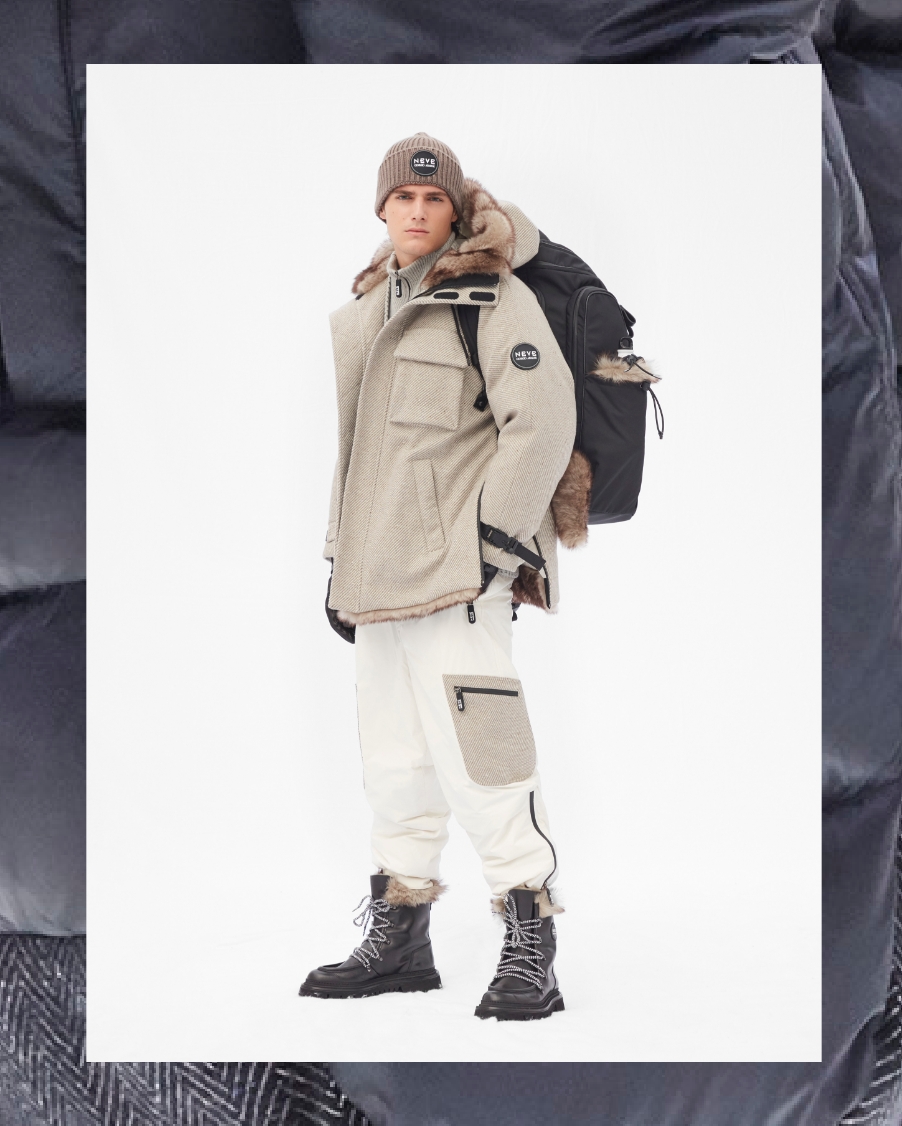 A man poses in light beige snow pants and jacket from Armani's FW21 Collection