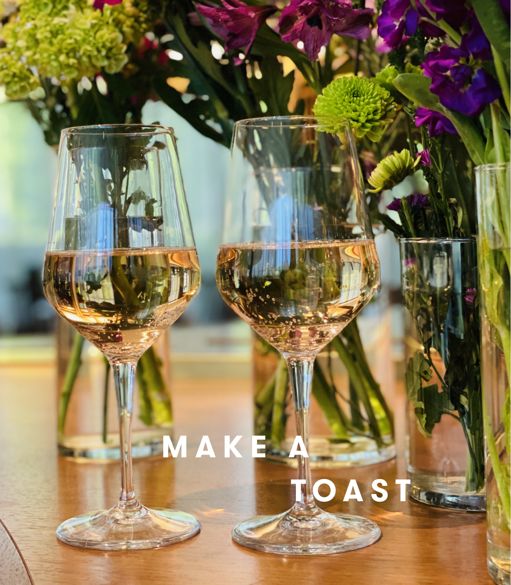 Two glasses of wine at Estuary restaurant at the Conrad, make a toast