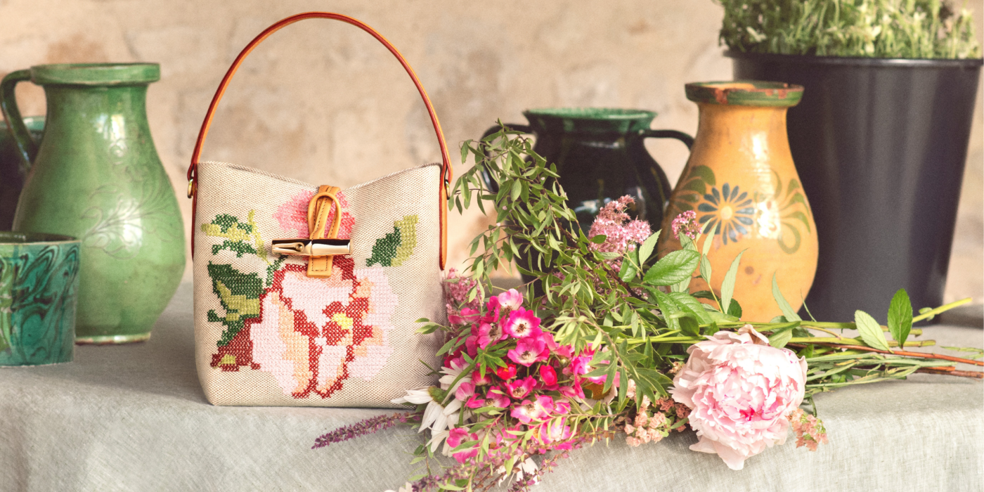 Bucket bag from Longchamp, flowers and objects on table
