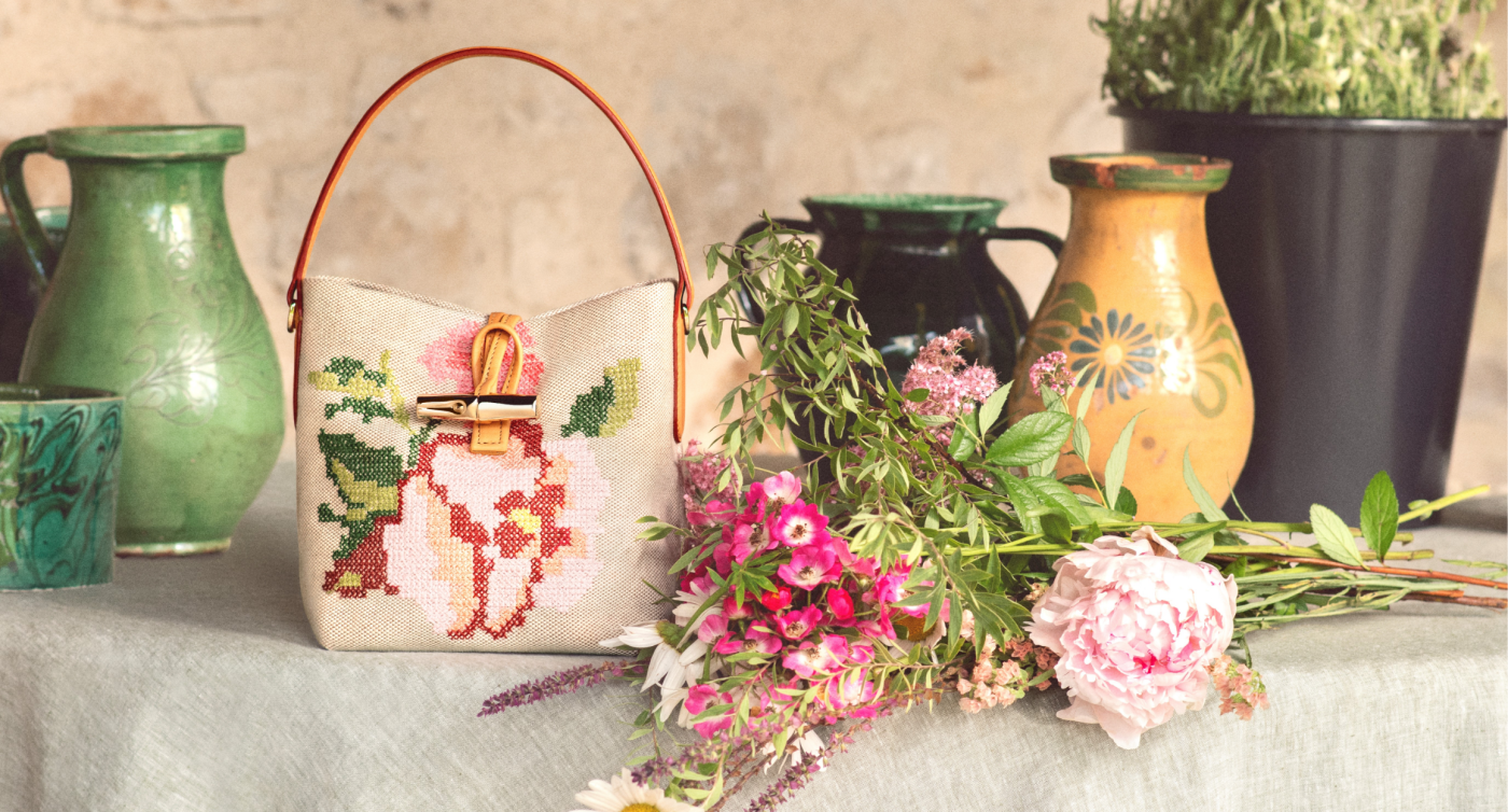 Bucket bag from Longchamp, flowers and objects on table