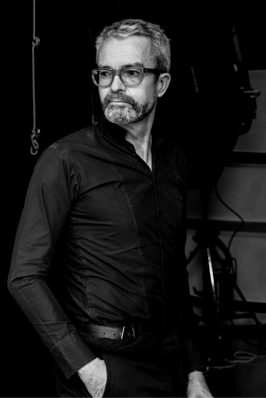 Black and white portrait of Albert Kreimler standing with one hand in pocket