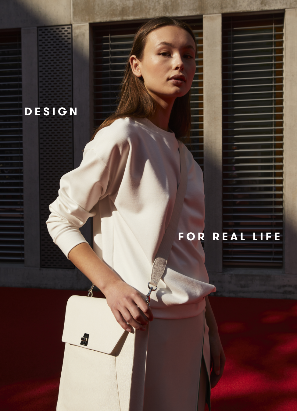 Woman wearing white outfit and shoulder bag from AKRIS