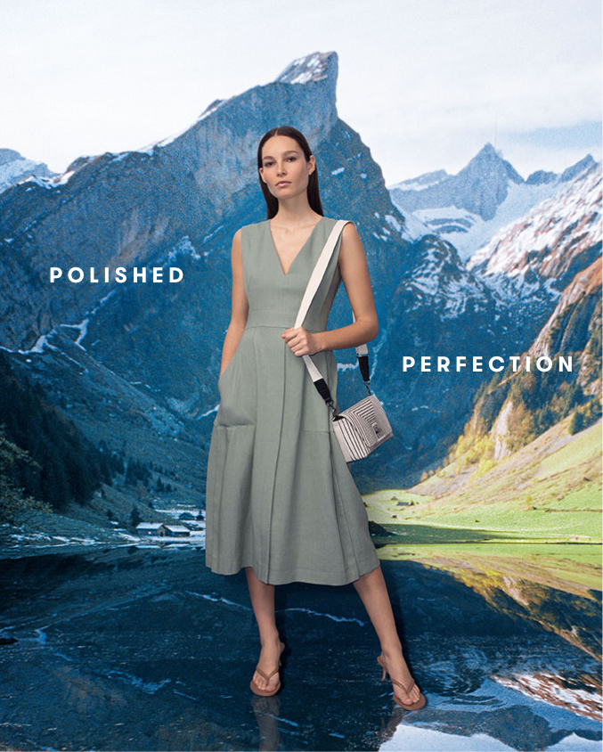 Woman wearing v neck dress from AKRIS standing in front of a mountain landscape background