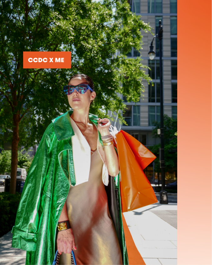Candace Ourisman holding orange shopping bags and standing on orange carpet