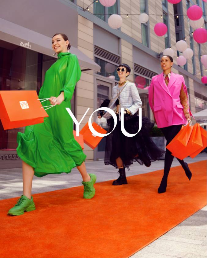 Three women walking in orange carpet while holding shopping bags in Palmer Alley in CityCenterDC
