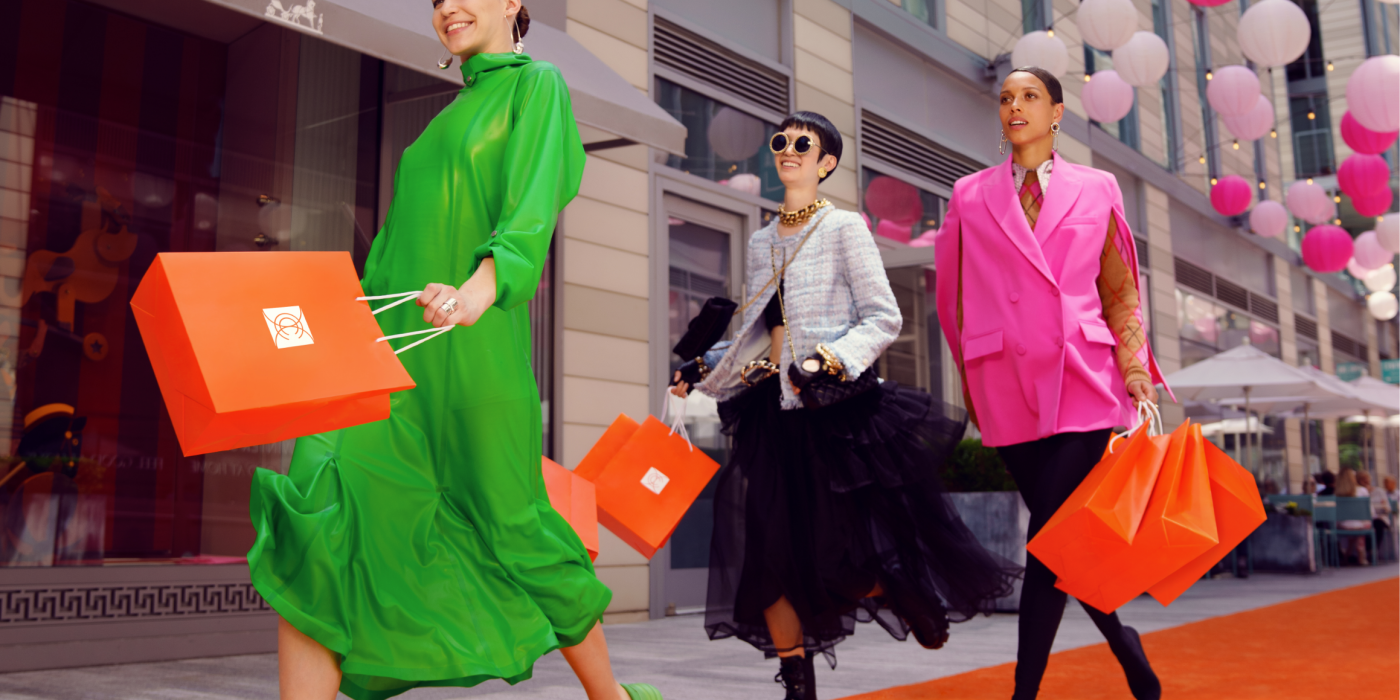 Three females waling down Palmer Alley while standing on orange carpet.