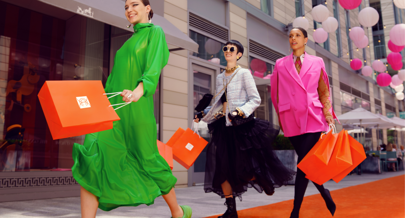 Three females waling down Palmer Alley while standing on orange carpet.